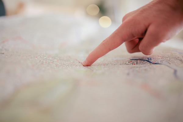 Un doigt pointe un endroit sur une carte