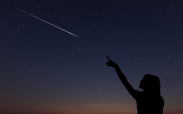 Une silhouette pointe une étoile filante